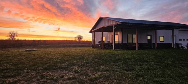 Modern home on acreage with pond, trails, rolling hills, and sunset views in Winterset